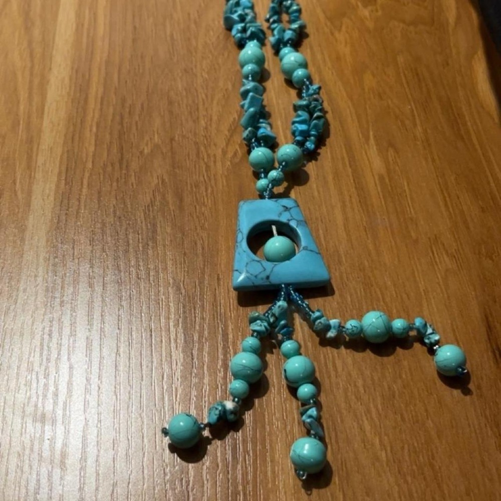 long turquoise beaded statement necklace features a geometric trapezoid